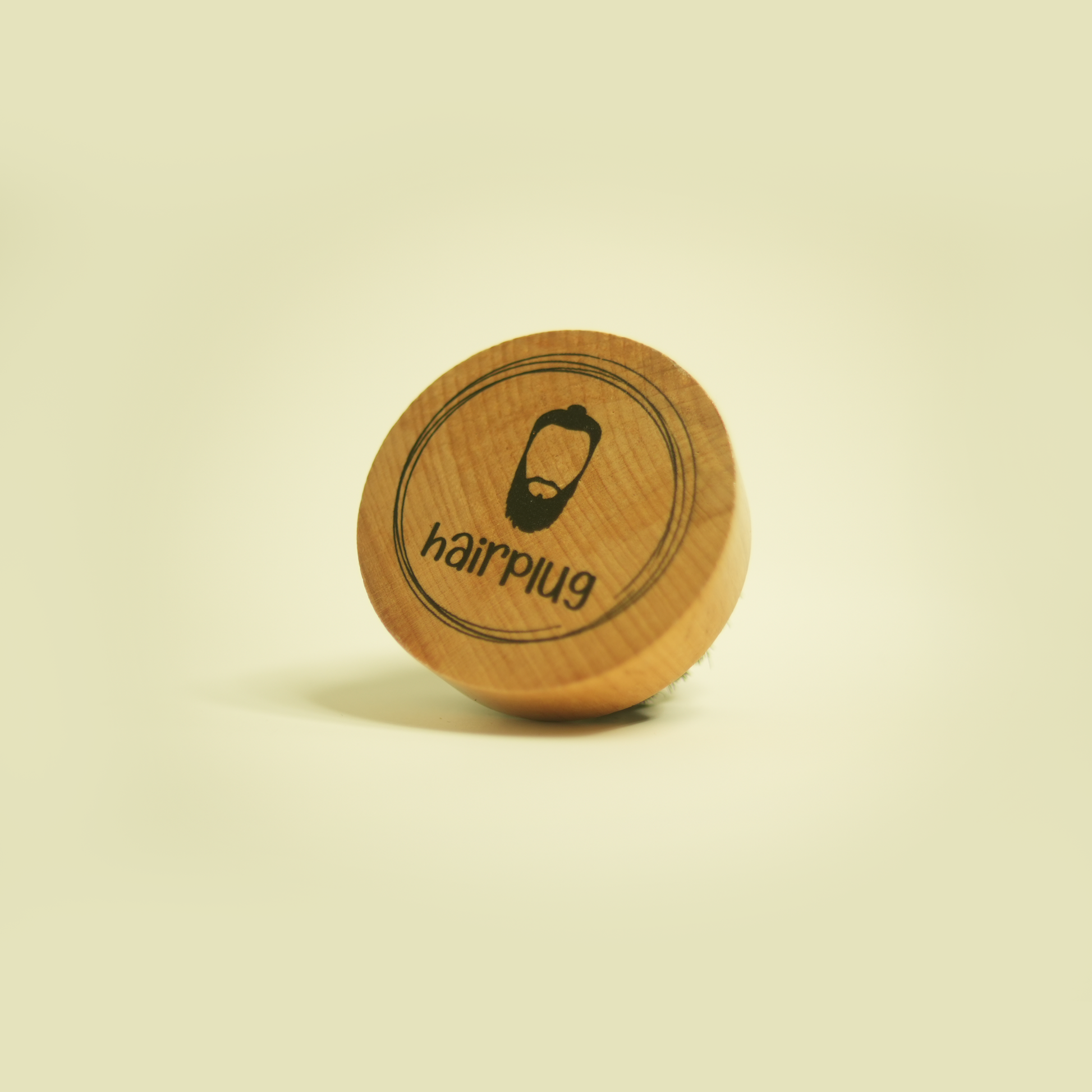 The Hairplug Beard Brush with natural boar bristles and a wooden handle.